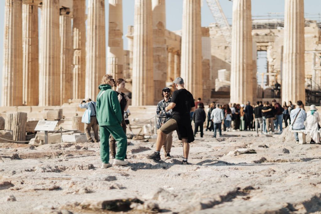 people walking around the ruins of the parthenon